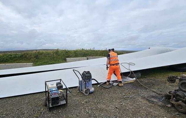 A technician cutting a wind turbine blade